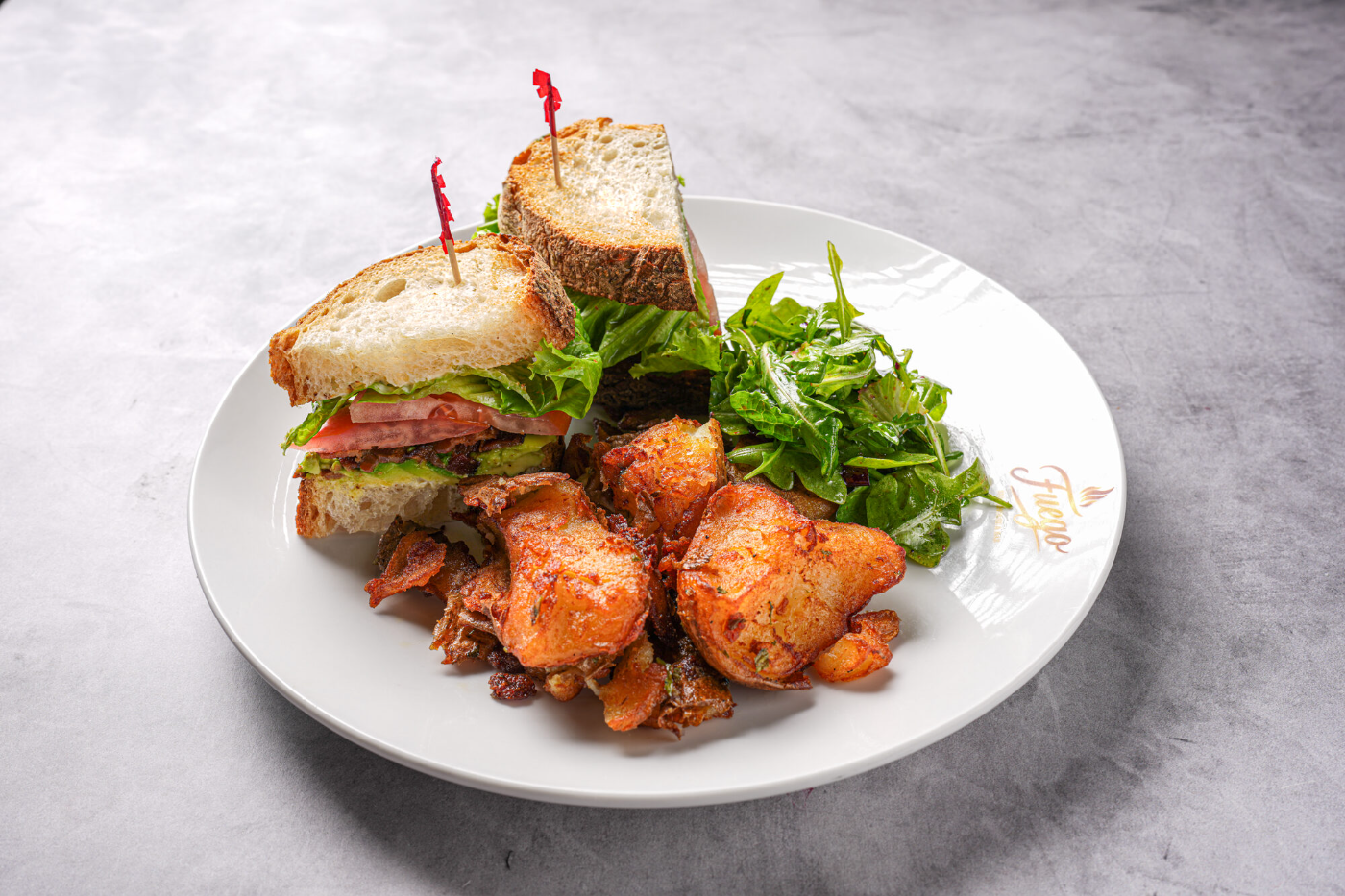 Crab cake brunch plate with arugula and breakfast potatoes